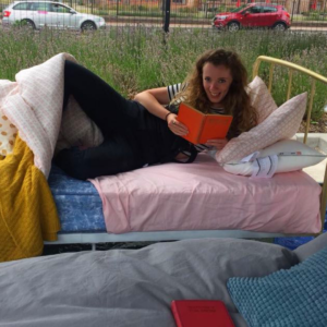 bethan seller chilling on a bed reading a book