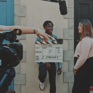 clapper board for uclan with students getting ready to act